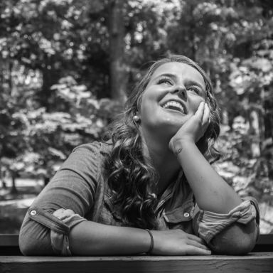 Photo en noir et blanc d'une femme souriante et pensive