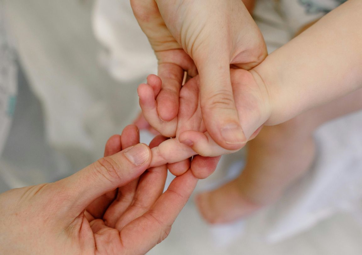 Photo d'une séance de réflexologie palmaire sur un bébé