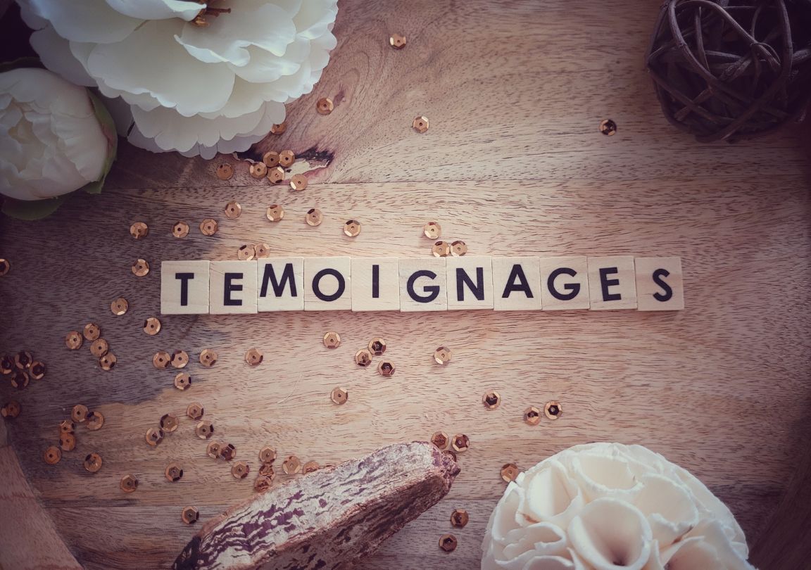 Photo lettres scrabble témoignages fleurs sur fond en bois