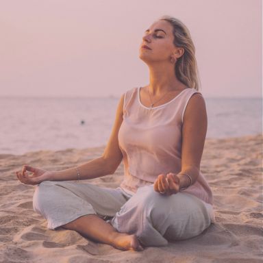 Photo femme assise à la plage posture zen réflexologie équilibre