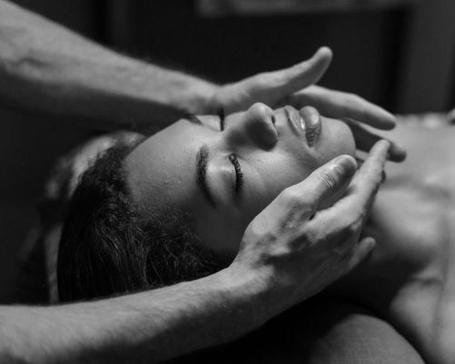Photo en noir & blanc d'une femme pendant une prestation de réflexologie faciale