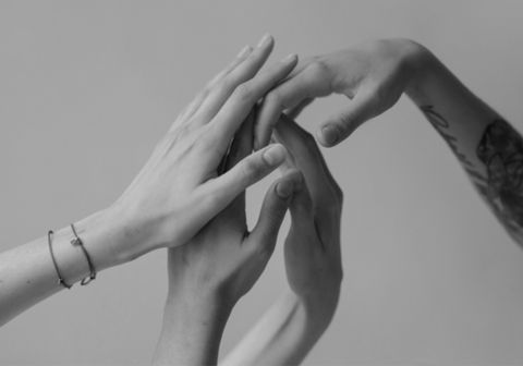 Photo noir et blanc de quatre mains entrelacées