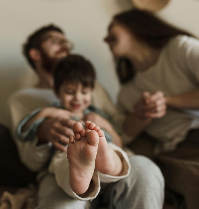 Mise en scène d'une famille, l'enfant présente ses pieds au premier plan