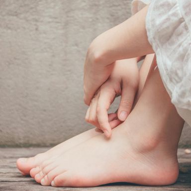 Mains posées sur les pieds avant séance de réflexologie plantaire
