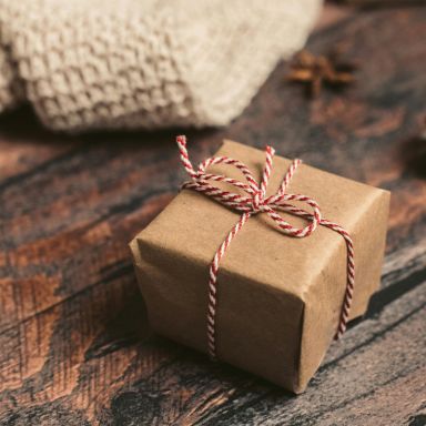 Un cadeau posé sur une table en bois.