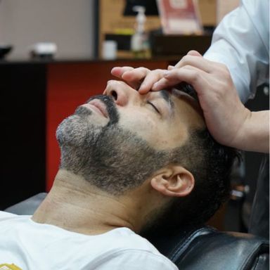 Prestation d'une réflexologie faciale sur un homme